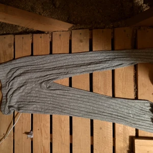 Grå ribbade mjukisbyxor - Mysiga grå mjukisbyxor med ribbad struktur och elastisk midja. Perfekta för chill dagar hemma eller när du vill vara extra bekväm. Byxorna har en rak passform och är tillverkade i mjukt material samt stretchiga 