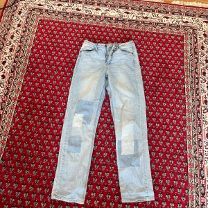 Raka rutiga jeans - Fina raka (straight leg) jeans från KappAhl med unikt rutigt mönster på framsidan. Sitter fint på kroppen och formar fint. Använd några gånger och normal i storleken. 98% bomull  
