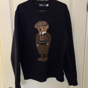 Polo Bear Ralph Lauren - Blå stickad tröja från Polo Ralph Lauren med klassisk Polo Bear-motiv på bröstet. Väldigt skön och sitter bra. Bra nu till höst och vintern. Priset kan diskuteras. Skriv vid fundering. OBS. Väldigt bra skick. Köpte den i juni. 