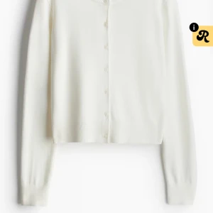 Vit kofta från H&M, XS - Snygg vit kofta från H&M i storlek XS. Modellen är croppad med långa ärmar och knappar framtill. Perfekt att slänga över ett linne eller t-shirt. Mjuk och tunn, passar bra till både jeans och kjol.