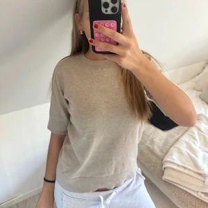 Beige stickad tröja från Åhléns - Snygg beige stickad tröja från Åhléns i storlek S. Tröjan har rund halsringning och korta ärmar. Bra skick, använt fåtal gånger, Tar frakt!