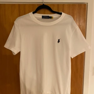 Vit t-shirt från Polo Ralph Lauren - Vit t-shirt från Polo Ralph Lauren med klassisk rund hals och korta ärmar. Säljer den eftersom den är för liten för mig därför bara använd ett fåtal gånger. Storlek L men passsar mer som M. Hör av dig vid fler frågor. Priset kan disskuteras 