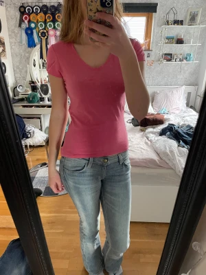 Rosa v-ringad topp från Amisu - !!DET ÄR INTE FLÄCKAR PÅ BILD 2 UTAN TRÖJAN SOM HAR VIKTS IN!! Säljer en rosa topp från Amisu i storlek M. Toppen har v-ringad hals, korta ärmar och är figurnära i modellen. Materialet är mjuk bomull. 