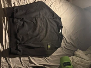 Stone island sweatshirt - Svart sweatshirt från Stone Island med klassisk rund hals och ikonisk patch med logga på vänster ärm. Tröjan är i mjuk bomull och har en clean, stilren look som passar perfekt till streetwear. Ribbstickade muddar vid ärmslut och nederkant för extra komfort.