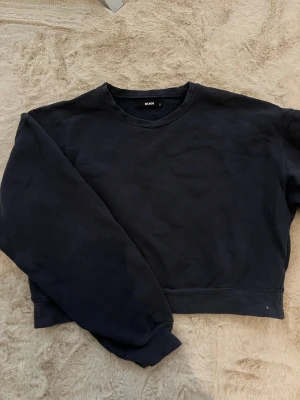 Marinblå sweatshirt från Bik Bok - En enkel och stilren marinblå sweatshirt från Bik Bok i storlek S. Tröjan har rund hals, långa ärmar och ribbade muddar vid ärmslut och nederkant. Perfekt för chill dagar och passar till allt. 