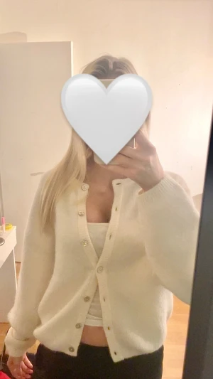 Vit kofta med knappar - Mysig vit kofta med långa ärmar och snygga knappar framtill. Koftan har en lite loose passform och är perfekt att ha över tröjor. Använt 1 gång och säljer pågrund av ingen användning. Pris kan diskuteras 