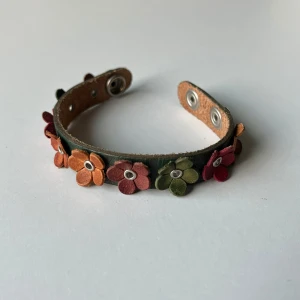Vintage armband - Unikt armband i vad jag tror är äkta läder med blommor på. Totalt 20,5 cm lång 