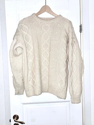 Vit stickad tröja med kabelmönster - Vit stickad , klassisk tröja i ullgarn . Varm o mysig !