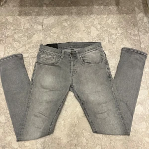 dondup george - Storlek 28 passar 29 Snygga grå jeans från dondup i skinny fit med klassisk femficksdesign och diskreta slitningar. Jeansen har en smal passform och är tillverkade i stretchig bomull med 2% elastan för extra komfort. Perfekt för dig som gillar en modern och stilren look.