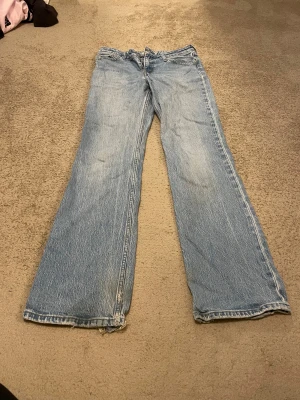 Levi's lågmidjade bootcut jeans   - Ljusblå lågmidjade bootcut jeans från Levi's. Snygg tvätt och lite slitna längst ned. Modellen är Low Pitch Boot. Ytterbenslängd 104, innerbenslängd 78, midjemått 37. 💕