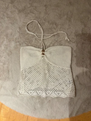 Vit stickad topp - Vit stickad topp i storlek s/m. Kan användas tom halterneck topp eller tubtopp💕