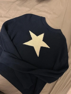 Mörkblå stickad tröja med tryck - Säljer en mörkblå stickad tröja med stjärntryck på från HM. Har endast använts cirka 1-2 ggr och säljer den eftersom den inte kommer till användning. Har inga skador eller defekter utan är som helt ny. Är i strl 158/164 men passar även mig som har xs/s. För referens är jag 160cm och den är perfekt i längden.