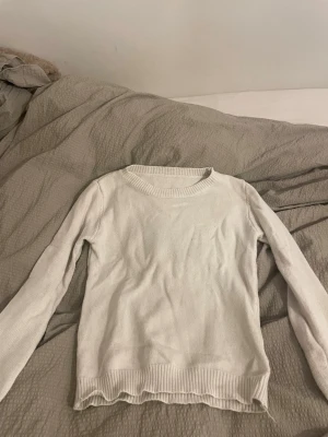 Vit stickad tröja från SHEIN XS - Säljer en enkel och stilren vit stickad tröja från SHEIN i storlek XS. Tröjan har rund hals, långa ärmar och ribbade muddar vid hals, ärmslut och nederkant. Perfekt för lager-på-lager under kyliga dagar.