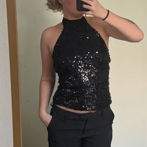 Glittrig halternecktopp  - En perfekt glittrig halterneck topp. Öppen rygg med svart tyg i ryggen. Storlek S/M. PERFEKT för nyår 😍