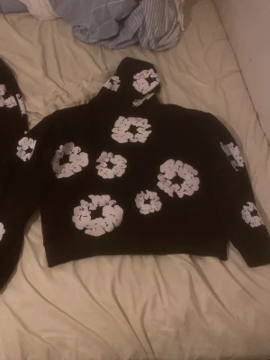 Denim Tears svarta mjukisbyxor S - PRIS KAN DISKUTERAS!   Svarta mjukisbyxor från Denim Tears med vita blommiga tryck över hela byxorna. Byxorna har resår i midjan och vid bensluten för en skön och avslappnad passform. Perfekt för chill dagar och streetwear-stil.