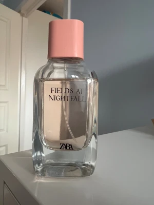 ZARA Fields at Nightfall parfym - Modern parfym med stilren design och rosa lock. Perfekt för dig som vill ha en trendig doft från ZARA. Flaskan är enkel att ta med och passar dig som gillar att sticka ut med något unikt.