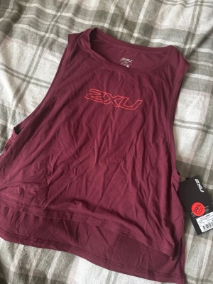 Snygg 2XU tränings topp - Säljer denna snygga tröja som har en fin röd färg. Den är aldrig använd köpt för 174,5 kr därför säljer jag för 90 kr pris går att förhandla. 