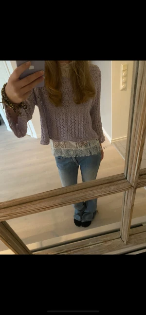 Ljuslila croppad stickad tröja ONLY - Säljer en ljuslila croppad stickad tröja från ONLY i storlek XS. Tröjan har ett snyggt hålmönster och trekvartsärmar, perfekt för dig som gillar en chill och trendig vibe. Materialet är mjukt och luftigt, och den har en vågig kant nedtill. 🎉