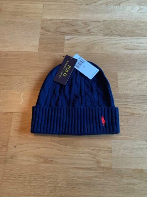 Blå Ralph Lauren mössa - En skön blå Ralph Lauren mössa. Ny i nyskick. Onesize