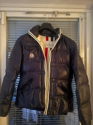 Moncler Jacka - Säljer en mörkblå Moncler branson jacka. Väldigt skön att ha till vintern, varm och passar bra. Inga defekter med den alls. Hör av vid frågor!☺️