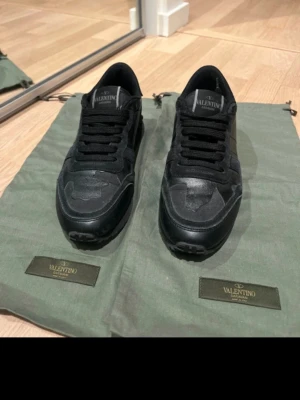 Svarta Valentino Garavani Rockrunner - Säljer ett par svarta Valentino Garavani Rockrunner sneakers som jag själv köpte idag, men pga en skada på min vänstra fot funkar de tyvärr inte. Super fina. De är som nya & kommer med dustbag. Är storleksmässigt som en 36:a så lite större i storlek, då de är 35. Jag har 36 & de passar bra.