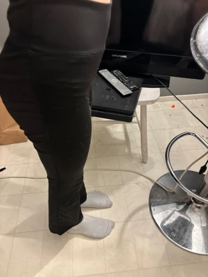 Svarta bootcut byxor med hög midja - Säljer ett par svarta bootcut byxor med hög midja. De har en tight passform över låren och blir vidare nedtill. Materialet känns mjukt och stretchigt, perfekt för dig som gillar bekväma och stilrena byxor. Passar dig som vill ha en clean look med lite edge.