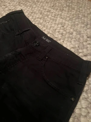 Svarta jeans från Armani Jeans Slimfit - Snygga svarta jeans från Armani Jeans med klassisk femficksdesign och metallogo på bakfickan. Byxorna har rak passform och är tillverkade i bomull med en mjuk känsla. 