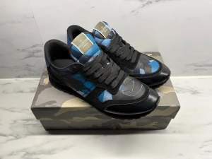 Valentino Garavani Rockrunner sneakers - Säljer ett par Valentino Garavani Rockrunner sneakers i svart och blått med coolt camouflage-mönster. Skorna har snörning, rund tå och platt sula. Materialmix av skinn och mocka med detaljer i syntet. Perfekta för dig som gillar streetstyle och exklusiva märken. Säljs då jag är sugen på annat. Självklart äkta