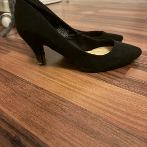 Svarta pumps från H&M, storlek 36 - Klassiska svarta pumps från H&M i storlek 36. Skorna har spetsig tå, låg klack och är klädda i mockaliknande material. Perfekta för dig som gillar en stilren och tidlös look med en elegant touch.