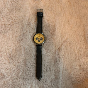 Sekonda gul kronografklocka - Snygg kronografklocka från Sekonda med gul urtavla och svart boett. Klockan har svart perforerat skinnarmband med gula sömmar och flera subdials för extra funktioner. Perfekt för dig som gillar sportig och modern stil.