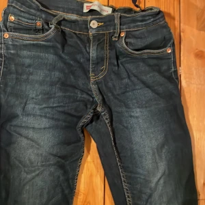 Levi's 512 Slim Taper jeans mörkblå - Snygga Levi's 512 Slim Taper jeans i mörkblå tvätt med klassiska kontrastsömmar och fem fickor. Modellen har smal passform med avsmalnande ben och normal midja. Perfekt för dig som gillar en modern och stilren look. Storlek 164 köpta på kidsbrandstore