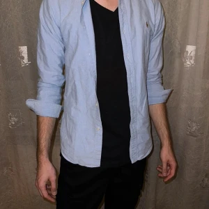 Blå slim fit skjorta från Ralph Lauren - Klassisk ljusblå skjorta från Ralph Lauren i slim fit-modell. Skjortan är använd 2 gånger Sitter som en S kan passa M