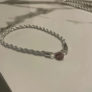 Cordell armband 4mm 20 cm s925 silver platerad - Snyggt flätat armband i silver platering med stämpel S925 på den runda brickan vid låset. Kedjan har en tvinnad design som ger en cool och stilren look. Perfekt för dig som gillar minimalistiska smycken med lite edge.