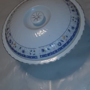 Produkt ej elektronik - Denna produkt är inte elektronik. Det är en porslinsskål med lock, dekorerad med blått blommönster och tillverkad i Kina. Skålen ser ut att vara i gott skick utan synliga sprickor eller större slitage.