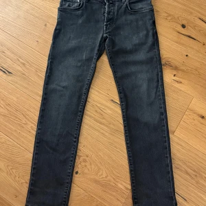 Jacob Cohën Nick Slim svarta jeans - Svarta jeans från Jacob Cohën i modellen Nick Slim. Snygg slim, Jeansen är tillverkade i Italien och har en diskret tvättad look med grå toner. Materialet är mjukt och stretchigt denim för skön passform.