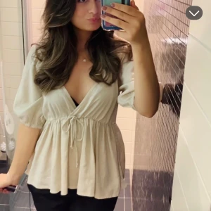 Beige omlottblus med puffärm - Säljer en beige omlottblus med v-ringning och puffiga trekvartsärmar. ❤️