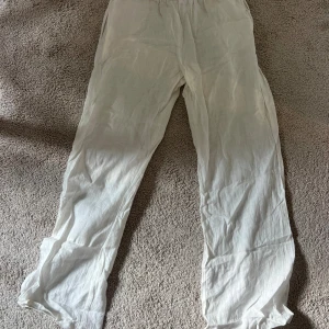 Vita linnebyxor med snörning - Säljer ett par vita linnebyxor med elastisk midja och snörning. Byxorna har rak passform och är tillverkade i ett lätt och luftigt linnematerial, perfekt för varma dagar. Enkel och stilren design som är lätt att matcha med olika toppar. Går att ha både låg och medel högmidjat❤️
