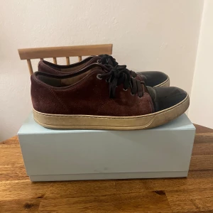 LANVIN skor (Bud på 800 just nu) - Dem är i relativt bra skick för att ha använts flitigt men man kan absolut rusta upp dem lite. Storlek 9 UK/43 EU. Boxen på bilden följer tyvärr inte med men jag ser till att packa dem bra oavsett. Finns två defekter på varsin sko vilket är att "Stygnen" på samma litet ställe på vardera sko har lossnat men går enkelt att fixa om man lämnar in dem hos en skomakare. Be om bilderna på defekterna privat då de inte får plats i annonsen! Tar emot bud.