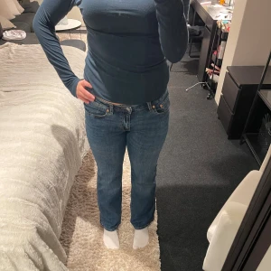 Blå bootcut jeans med raka ben - Snygga blå jeans med klassisk bootcut och raka ben. Jeansen har fem fickor, synliga sömmar och knappstängning fram. Materialet är slitstarkt jeans och passformen är normal med medelhög midja. Perfekt för dig som gillar en tidlös och avslappnad stil.