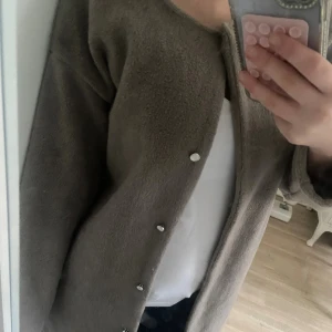 Beige teddyjacka från Fashion - Mysig beige teddyjacka från Fashion Classic Fashion Collection. Jackan har rund hals, långa ärmar och knäpps med silvriga knappar framtill. Perfekt för dig som gillar en chill och kanske lite vintage stil nu till höst och vår ☕️🍂😍