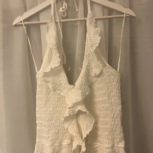 Vit volangtopp med knyt - Vit volang halterneck topp, helt oanvänd.
