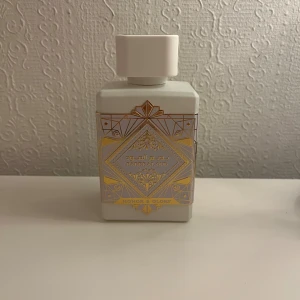 Bade'e Al Oud Honor & Glory - Stilren parfym från Lattafa med lyxig design. Eau de Parfum, 100 ml. Tillverkad i U.A.E. Perfekt för dig som vill sticka ut med något unikt. Helt otrolig doft som kommer få folk att vända sig om och fråga vad du har för parfym så gott den luktar. Passar herr såväl som Dam.         Toppnoter: Ananas och crème brûlée.  ￼ 	Mellannoter: Kanel, gurkmeja, svartpeppar och bensoin.  ￼ 	Basnoter: Vanilj, sandelträ, cashmeran/träig “cashmere wood” och mossa.  