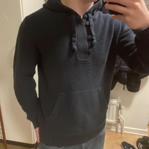 Blå unik stickad hoodie - Riktigt fet stickad blå hoodie med knappar. Perfekt till kallare väder. Modellen är 180cm, 73kg. Priset går att diskutera!
