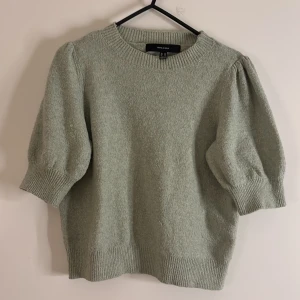 Ljusgrön stickad tröja Vero Moda - Superfin ljusgrön stickad tröja från Vero Moda med puffade korta ärmar och ribbade muddar. Tröjan har en croppad passform och rund halsringning, perfekt för dig som gillar en chill och trendig look.