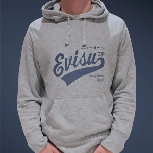 Grå hoodie från Evisu med tryck - Asfet hoodie från Evisu. Självklart ÄKTA (SE BILDER) Den har ett stort mörkblått logotryck på bröstet och japanska tecken som betyder ”New York”. Snygg vintage slitage som ackumulerats med tiden. En av mina favoritplagg men säljs nu och vid snabb affär kan priset sänkas.  Modellen är 189, väger 78 Ha det gött! // Gidlöfs