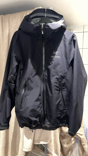 Arc’teryx Beta SL toppskick,  herr (storlek M) - Arc’teryx Beta SL i superfint skick. Jackan är mycket sparsamt använd och har inga tecken på slitage. Alla detaljer såsom tejpade sömmar, loggor och material är i originalskick. Jackan är inköpt i januari 2023 för ca 5500kr. Kvittot finns tyvärr inte kvar då det låg på en mailadress jag inte längre har tillgång till. För att kompensera för detta har jag lagt upp tydliga närbilder på alla kännetecken som visar att jackan är äkta, tejpade summar och loggor. Kan även skicka bild på tvättlappar.