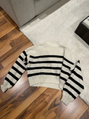 Randig stickad tröja - Jättesnygg vit stickad tröja med svarta ränder från Nelly i storlek XXS