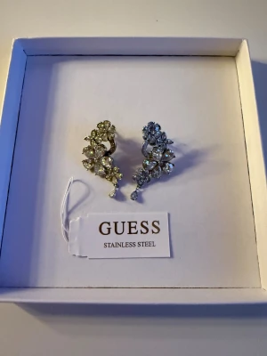 Guess öronhängen - Guess örhängen i silverfärg med smyckeskristall i material ädelstål, org. pris 799kr, säljs 700kr eller närmast bud💖 aldrig använda så i nyskick😊💕 vid frågor, skicka meddelande🥰