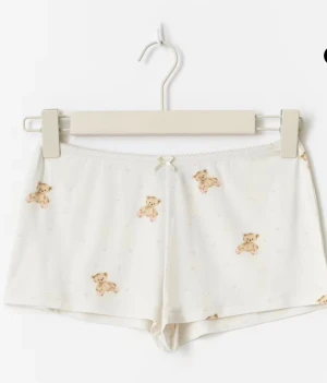 pyjamas shorts - säljer pyjamas shorts från gina tricot som aldrig använts! de är beiga med söta nallebjörnar och små rosa hjärtan på. de är för korta för mig och det är för sent att lämna tillbaka! inga fläckar eller skador! de är supermjuka och sköna! helt nya utan prislapp! skriv om ni har frågor!