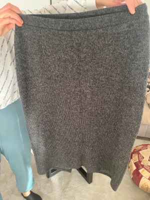 Grå ribbad långkjol från Vero Moda - Säljer en grå långkjol från Vero Moda i ribbad stickad kvalitet. Kjolen har en enkel och rak form med mjuk stretchig midja. Perfekt för dig som gillar chill och stilren look. Passar dig som vill ha en bekväm och snygg kjol till garderoben.